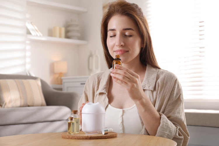 Une femme utilise les huiles essentielles pour son bien-être.